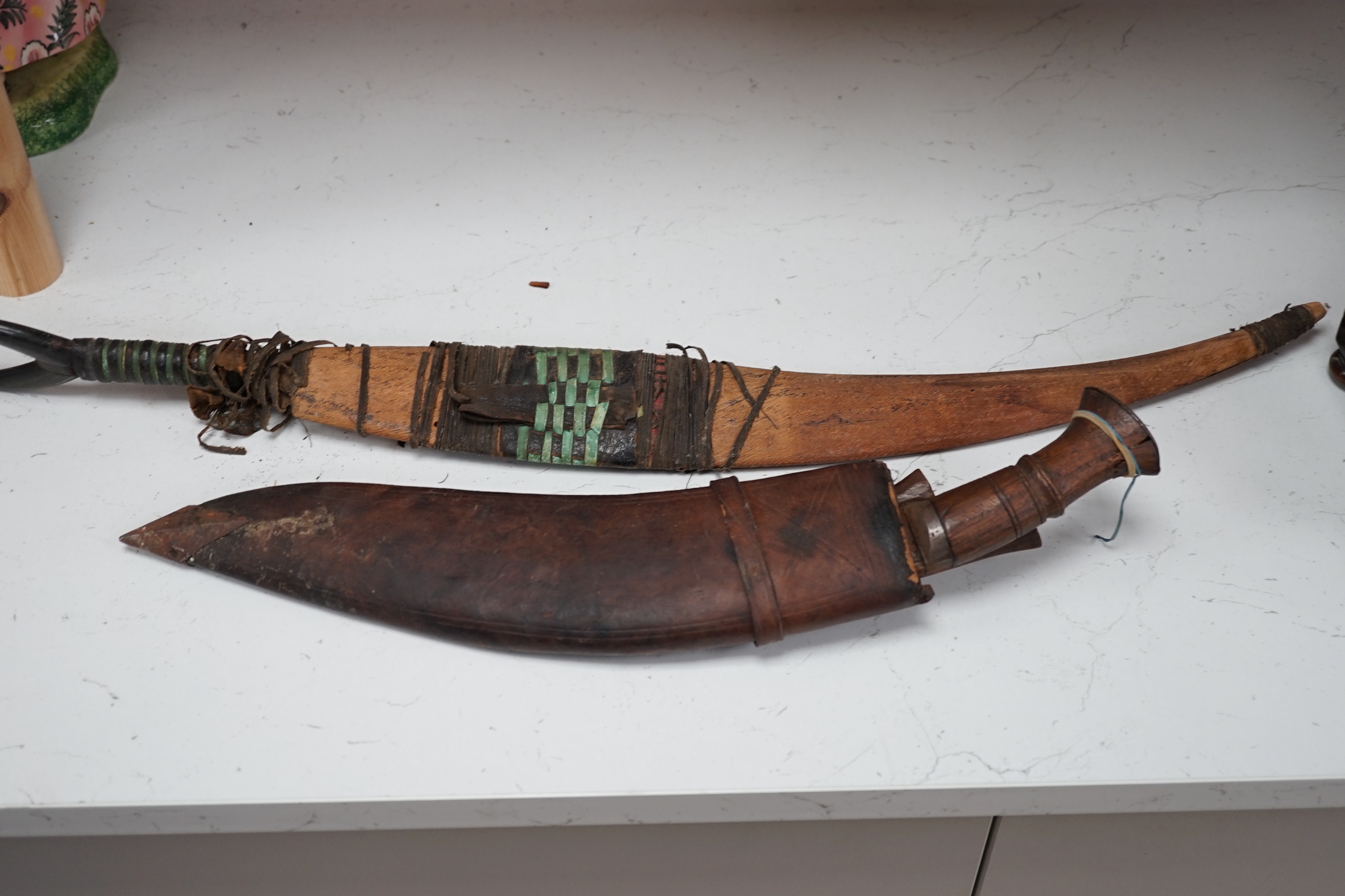 A kukri, a long dagger and sheath, a mace, and two African ebony busts